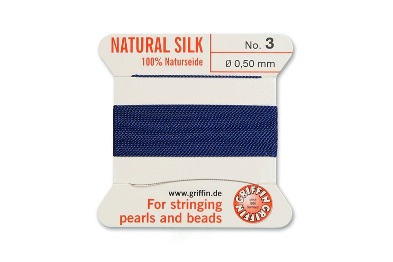 May include: A spool of dark blue natural silk thread for stringing pearls and beads. The spool is labelled "NATURAL SILK 100% Naturseide No. 3 &Oslash; 0,50 mm" and "For stringing pearls and beads".
