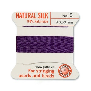 May include: A spool of purple natural silk thread for stringing pearls and beads. The spool is labelled "NATURAL SILK 100% Naturseide No. 3 &Oslash; 0,50 mm" and "For stringing pearls and beads www.griffin.de".