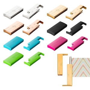 Op de afbeelding: Een assortiment van kleurrijke, metalen en plastic gespen voor geweven banden. De gespen zijn in verschillende kleuren, waaronder zilver, goud, rosé goud, zwart, blauw, roze en groen. De gespen zijn open en gesloten, waardoor het mechanisme zichtbaar is. De gespen hebben het woord "hiilos" erop gedrukt.