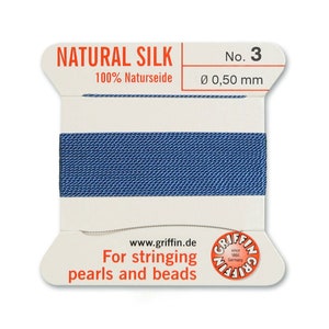 May include: A spool of blue natural silk thread for stringing pearls and beads. The spool is labelled "NATURAL SILK 100% Naturseide No. 3 &Oslash; 0,50 mm" and "For stringing pearls and beads".