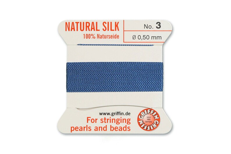 May include: A spool of blue natural silk thread for stringing pearls and beads. The spool is labelled "NATURAL SILK 100% Naturseide No. 3 &Oslash; 0,50 mm" and "For stringing pearls and beads".