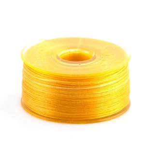 May include: A spool of bright yellow thread wound around a clear plastic bobbin.