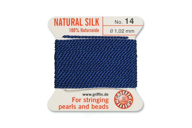 Puede incluir: Una bobina de hilo de seda natural azul oscuro para enhebrar perlas y cuentas. La etiqueta dice "NATURAL SILK 100% Naturseide No. 14 &Oslash; 1,02 mm www.griffin.de For stringing pearls and beads"