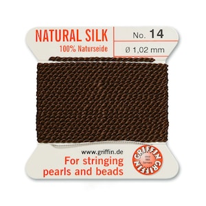 Puede incluir: Cord&oacute;n de seda natural marr&oacute;n para enhebrar perlas y cuentas. El cord&oacute;n es 100% seda natural y tiene un di&aacute;metro de 1,02 mm. La etiqueta dice "NATURAL SILK 100% Naturseide No. 14 &Oslash; 1,02 mm www.griffin.de For stringing pearls and beads"