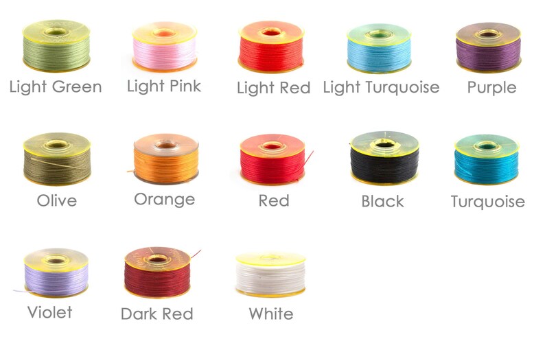 May include: Assortment of thread spools in various colours, including light green, light pink, light red, light turquoise, purple, olive, orange, red, black, turquoise, violet, dark red, and white.