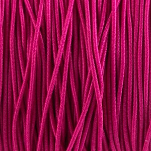 May include: Close-up of a bundle of pink elastic cord. The cord is tightly wound together, creating a smooth, textured surface.