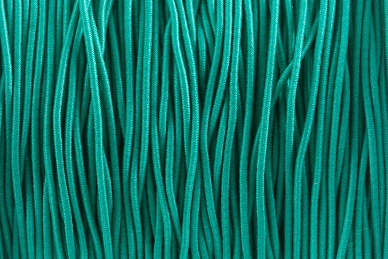 May include: Close-up of a bundle of teal-colored paracord.
