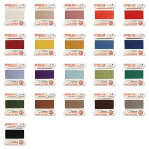 Könnte beinhalten: Sortiment von 25 Spulen mit Naturseidenfaden in verschiedenen Farben. Jede Spule ist mit "Naturseide" beschriftet und 0,80 mm dick. Der Faden ist zum Fädeln von Perlen und Perlen.