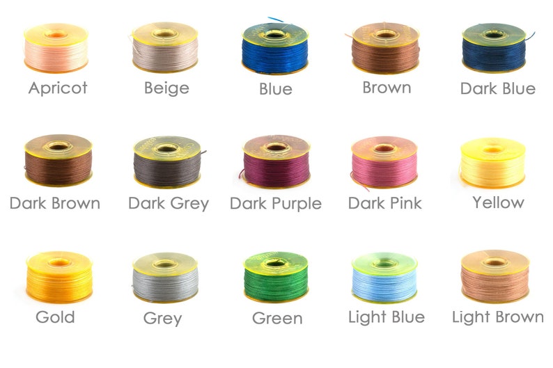 May include: A collection of 15 spools of thread in various colours, including apricot, beige, blue, brown, dark blue, dark brown, dark grey, dark purple, dark pink, yellow, gold, grey, green, light blue, and light brown.