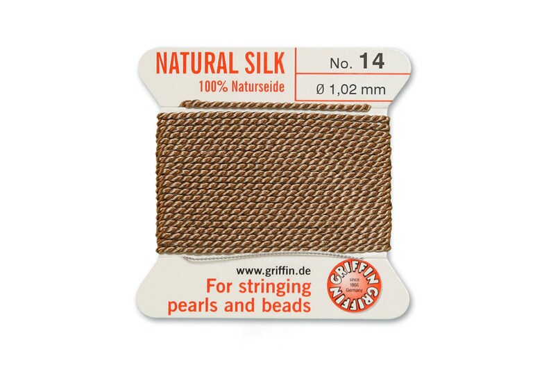 Puede incluir: Una bobina de hilo de seda natural para enhebrar perlas y cuentas. La bobina est&aacute; etiquetada "NATURAL SILK 100% Naturseide No. 14 &Oslash; 1,02 mm" y "Para enhebrar perlas y cuentas".