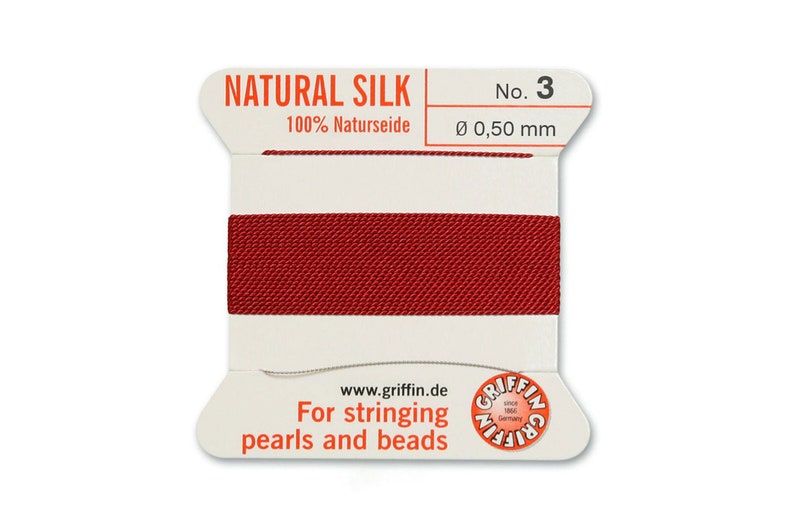 May include: A spool of red natural silk thread for stringing pearls and beads. The spool is labelled "NATURAL SILK 100% Naturseide No. 3 &Oslash; 0,50 mm" and "For stringing pearls and beads".