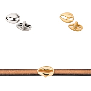 Op de afbeelding: Twee schelpvormige gespen voor leren banden, twee goudkleurig en twee zilverkleurig. Een gouden gesp is bevestigd aan een bruin leren band.