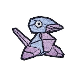 May include: Purple and blue embroidered patch of a cartoon bird with a geometric design.