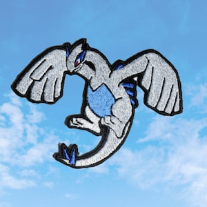 Puede incluir: Un parche bordado que representa una criatura mítica con alas, que se asemeja a un pájaro o un dragón. La criatura es blanca con detalles azules.