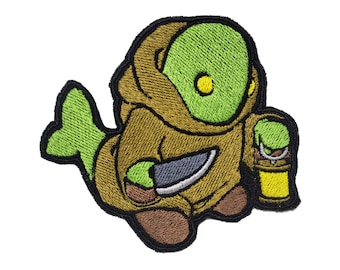 May include: An embroidered patch featuring a green and brown creature with a knife and a lantern. The creature has a large head and a small body. The patch is perfect for adding a touch of whimsy to your belongings.