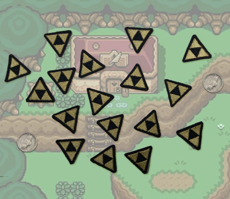 May include: A collection of 15 gold and black triangular patches with a stylized design. The patches are arranged on a green and brown background with a pixelated design.