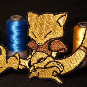 Abra - Glänsande metalliskt broderi stryk-på märke. Pokémon märke.