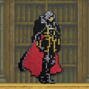 May include: A black and red embroidered patch of a character wearing a black cape and gold trim. The character has a white face and black hair.