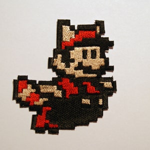8-bits Mario of Luigi Racoon Tail glanzende metalen borduuropstrijkpatch. Super Mario Bros. Pixelart.