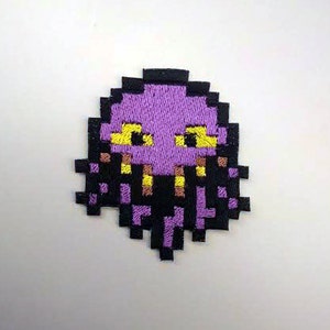 May include: Purple pixelated embroidered patch of a creature with yellow eyes and a black and purple tentacled body.