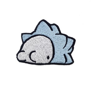 May include: A blue and white embroidered iron-on patch of a cartoon character with a spiky blue head and a white face.