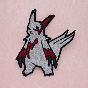Peut inclure: Patch brodée thermocollante représentant une créature mythique grise et rouge avec des griffes acérées et une queue pointue.