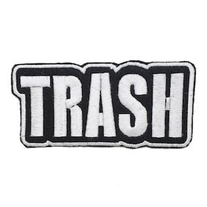 May include: Black and white embroidered patch with the word "TRASH" in white lettering.