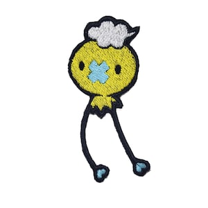 May include: A yellow embroidered patch with a black outline depicting a cartoon character with a cloud-shaped head, blue eyes, and a blue X over its mouth. The character has long, thin legs.