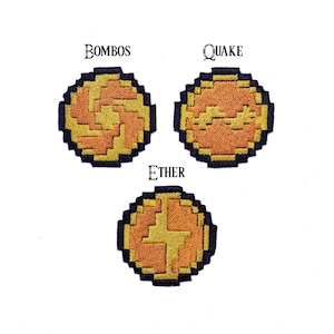 May include: Three embroidered patches with pixelated designs. The top patches read "BOMBO" and "QUAKE", while the bottom patch reads "ETHER". Each patch features a circular design with orange and yellow colors, outlined in black.