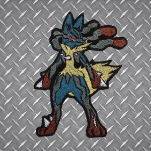 May include: Embroidered patch featuring a Lucario character in shades of blue, brown, yellow, and gray. The patch has a detailed design with a textured appearance. The background is a diamond plate pattern.
