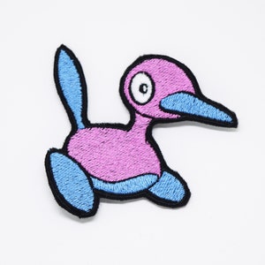 Può includere: Toppa ricamata raffigurante un personaggio a forma di uccello dei cartoni animati. La toppa ha un corpo rosa, becco blu e dettagli blu su piedi e coda. Il design è delineato con filo nero. Adatta per abbigliamento o accessori.