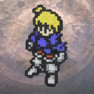 May include: A pixelated embroidered patch depicting a character with blonde hair, a blue shirt, and white trousers. The character is standing with their right leg forward.