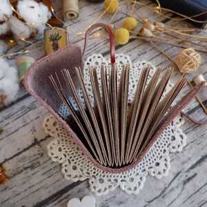 May include: A brown leather-bound journal with a burgundy cover and a lace doily underneath. The journal is open, revealing blank pages.