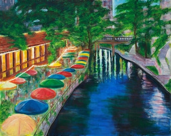 May include: A painting of a river scene with colorful umbrellas lining the edge of a walkway. The river is blue and reflects the surrounding trees and buildings. The umbrellas are red, yellow, green, and blue.