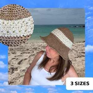 Può includere: Un cappello da sole intrecciato marrone e beige con una striscia bianca. Il cappello ha un'ampia tesa e una corona arrotondata. L'immagine mostra anche un primo piano del cappello e il testo "3 TAGLIE".