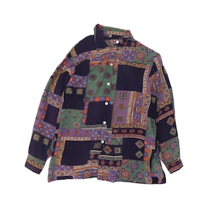 May include: A long-sleeved button-down shirt featuring a patchwork pattern of dark navy, sage green, and purple blocks. The design includes intricate geometric, floral, and paisley motifs within each section, finished with a standard collar.