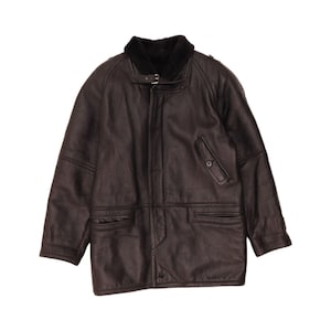 May include: A dark brown leather jacket with a black fur collar. The jacket features a button closure, two front pockets, and a small chest pocket. The jacket is a medium length and has a vintage aesthetic.