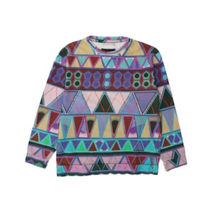 Può includere: Una felpa a maniche lunghe con girocollo caratterizzata da un vivace motivo geometrico ripetuto. Il design presenta fasce orizzontali di triangoli, esagoni e rombi nelle tonalità del viola, ottanio, rosa, bordeaux e beige.