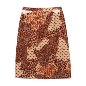 May include: A knee-length skirt with a patchwork design in shades of brown and beige. The skirt features various floral and geometric patterns, creating a vintage aesthetic. The fabric appears to be a woven material.