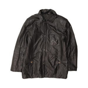 May include: A dark brown leather jacket featuring a classic collar, a front button closure with metallic snaps, long sleeves, and a single chest pocket on the left side. The garment has a structured fit with visible seam detailing throughout the front.