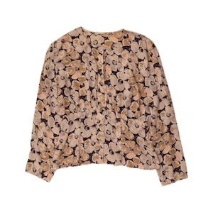 May include: A long-sleeved button-down blouse featuring a repeating abstract floral pattern in shades of beige, tan, and dark brown. The garment has a round neckline, a central vertical button placket, and subtle gathering at the waistline.