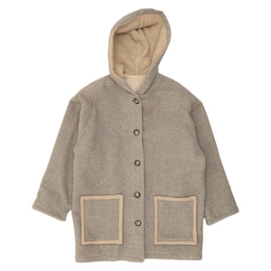 May include: A light grey hooded jacket featuring a beige interior lining, long sleeves, and a front button closure. The garment includes two square patch pockets on the front, each accented with a beige trim that matches the hood lining.