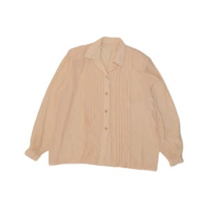 May include: A long-sleeved button-down shirt in a soft peach colour. The shirt features a classic collar and vertical pleats running down the front placket on both sides of the buttons. The sleeves are finished with simple cuffs at the wrists.