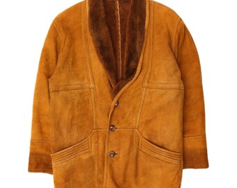 May include: A vintage brown suede jacket with a shearling collar and lining. The jacket has a button-up front, two front pockets, and a classic design. The jacket is a warm, stylish outerwear piece.