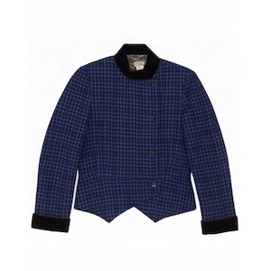 Peut inclure: Une veste à motif pied-de-poule bleu et noir avec un col en velours noir et des poignets en velours assortis. La veste présente une fermeture frontale asymétrique avec quatre boutons foncés et un ourlet pointu. La doublure est à motifs.