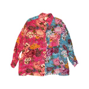 May include: A long-sleeved button-down shirt featuring a split-panel design with a vibrant pink floral print on the left side and a bright blue floral print on the right side. The shirt includes a collar, a single chest pocket, and buttons.