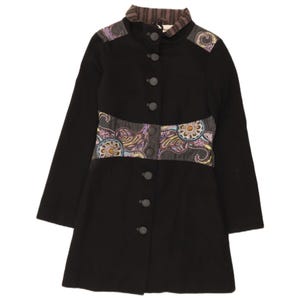 May include: A black coat featuring a high collar with brown and black vertical stripes, long sleeves, and a front button closure. The garment includes decorative panels at the shoulders and waist with a colourful paisley and floral pattern.