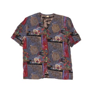 May include: A short-sleeved button-down shirt featuring a multi-coloured print with blue, red, and black tones. The pattern includes rectangular frames, outlined heart shapes, and floral motifs. The shirt has a round neckline and gold-toned buttons.