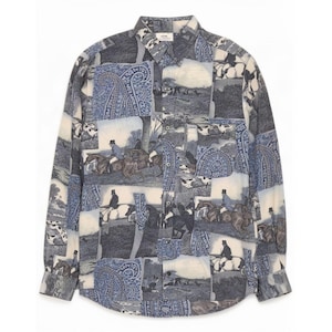 May include: A long-sleeve button-down shirt featuring a collage print of equestrian scenes with riders on horseback and blue paisley patterns. The shirt has a standard collar, a front button placket, and a curved hemline in shades of blue and cream.