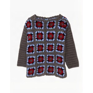 Op de afbeelding: Een trui met lange mouwen gemaakt van gehaakte granny squares. De vierkantjes hebben een centraal rood bloemmotief omringd door zwart, lichtblauw en donkergrijs garen. De mouwen en randen zijn gemaakt van effen donkergrijs haakwerk.
